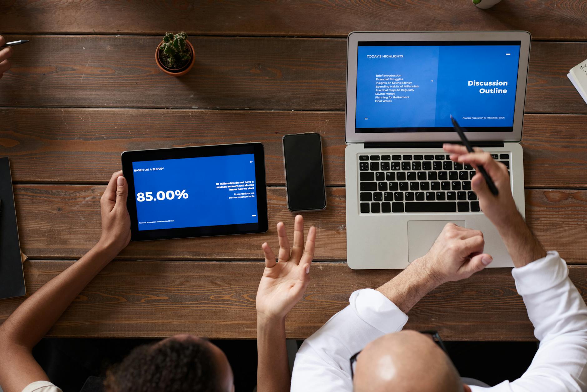 Overhead view of professionals collaborating on digital devices during a meeting at the office.