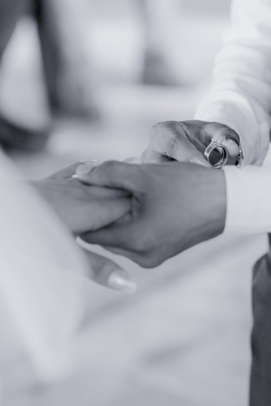A tender black and white image of a couple holding hands, symbolizing love.