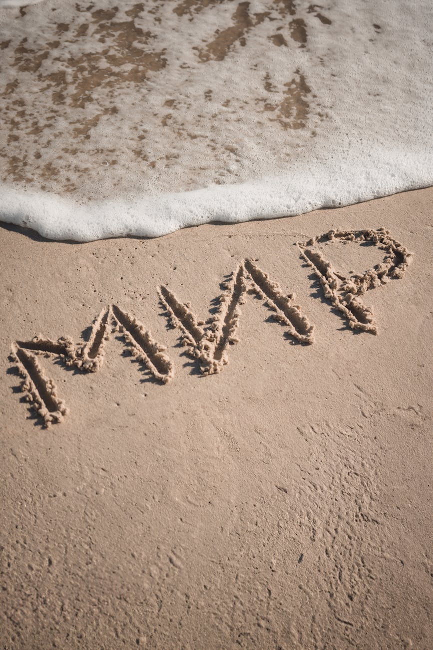 "MVP" carved in sand near sea foam on Odessa beach captures tranquility.