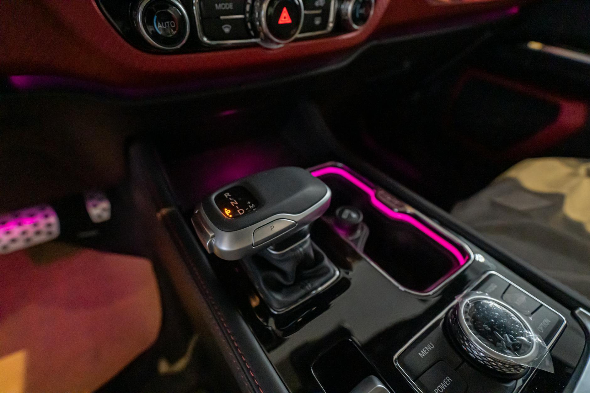 Close-up of a luxury car's gear shift with ambient lighting in Dubai.