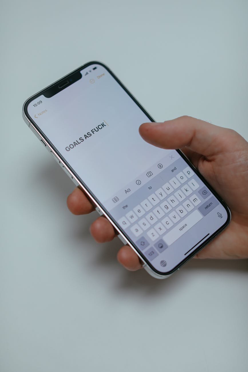 Close-up of a hand holding a smartphone displaying a motivational message, emphasizing goals.
