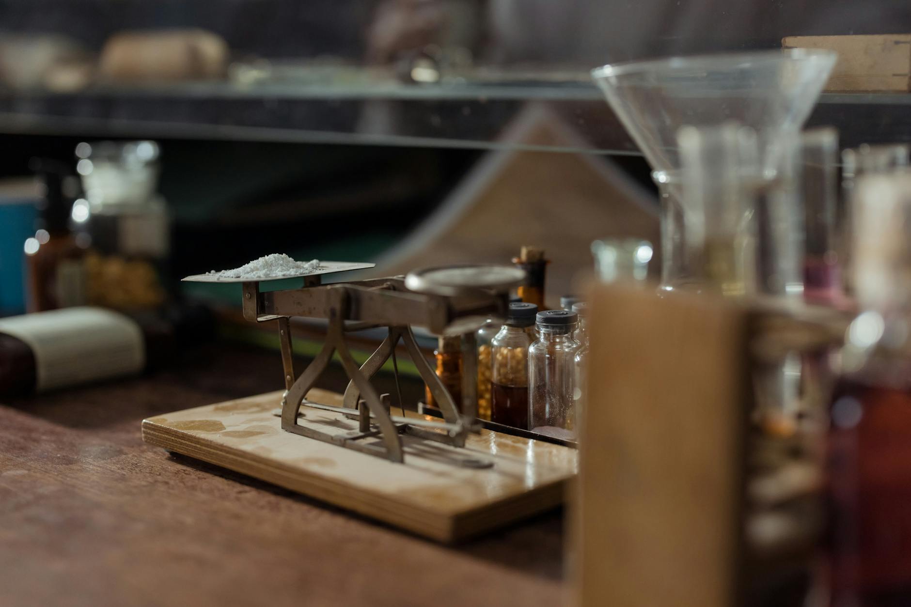 Close-up of an antique apothecary scale with pill bottles in a vintage pharmacy setting.