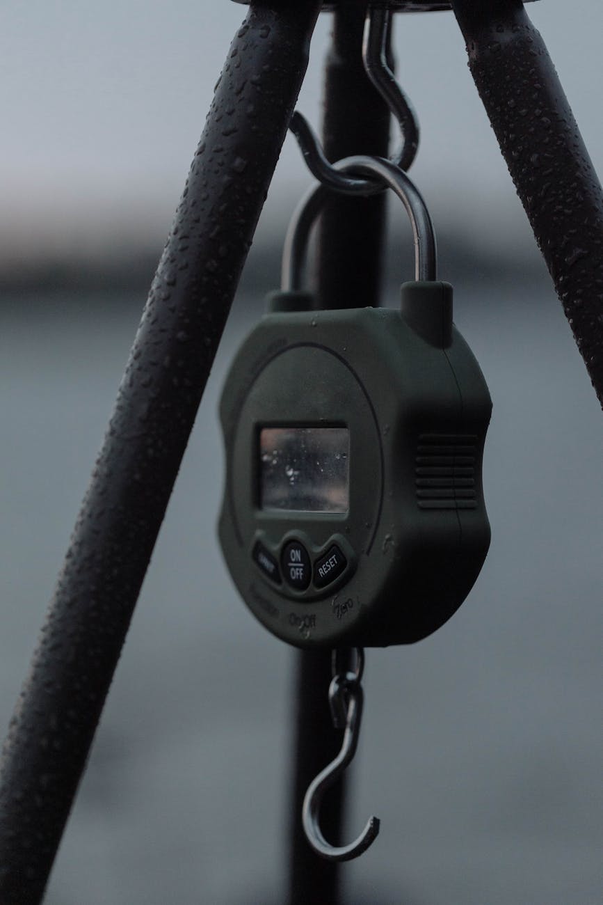 Close-up of a digital fishing scale with waterdrops, highlighting its robust design for outdoor use.
