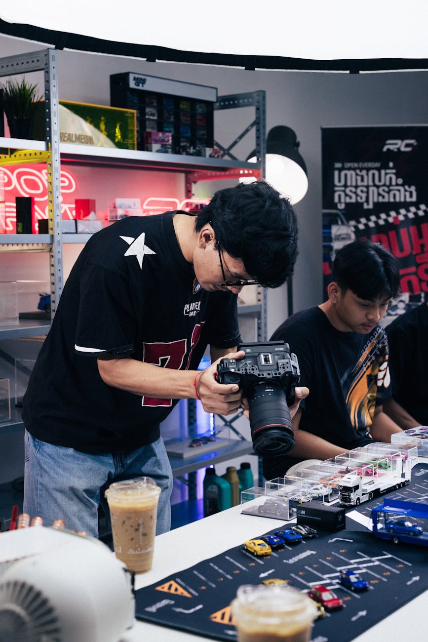 Photographer taking pictures of diecast car models in a studio setting in Phnom Penh.
