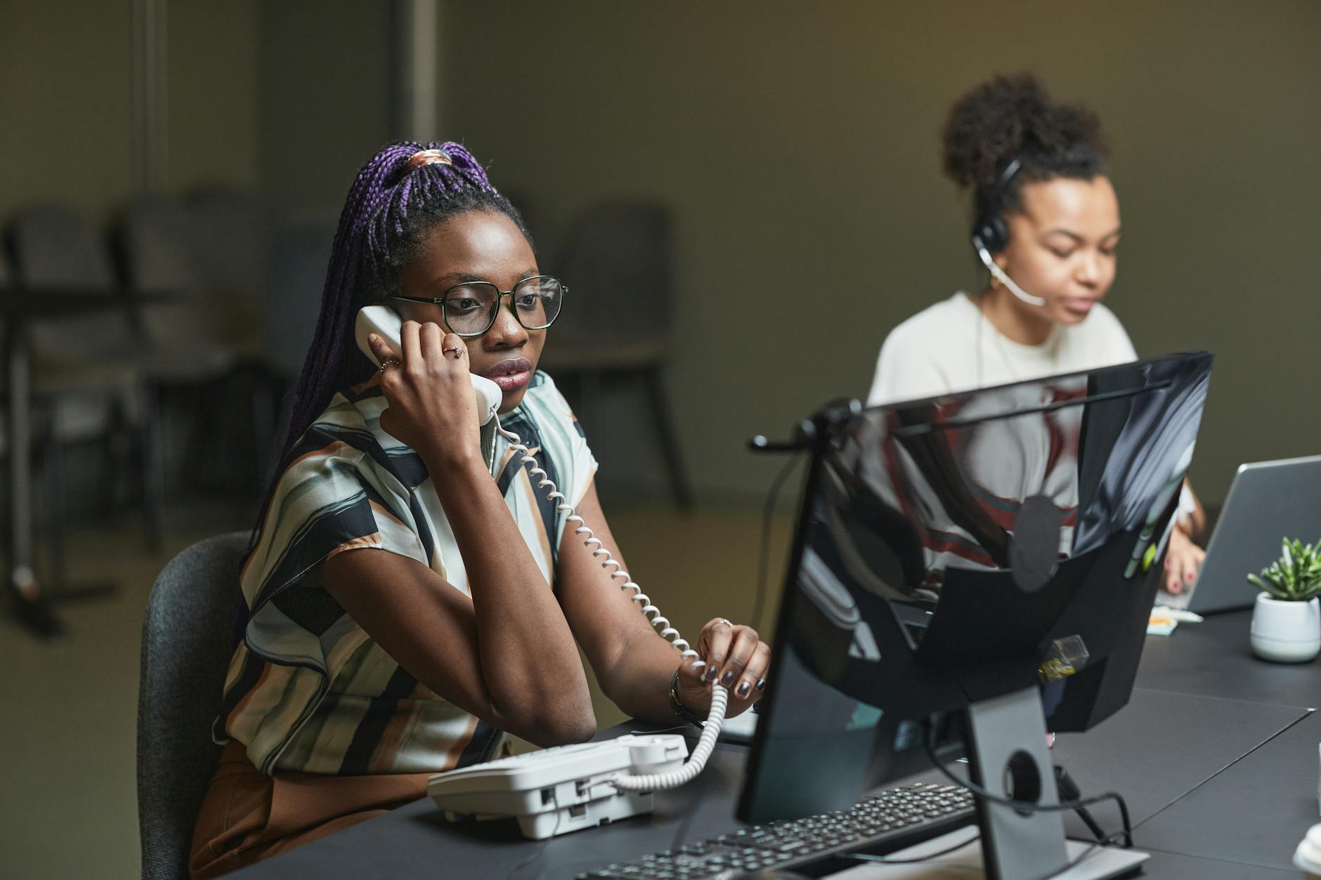Call center agents working in an office, focusing on customer service and communication.
