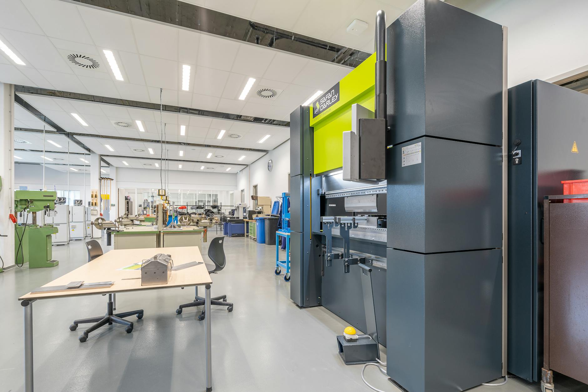 Spacious industrial workshop featuring advanced machinery and organized workstations.