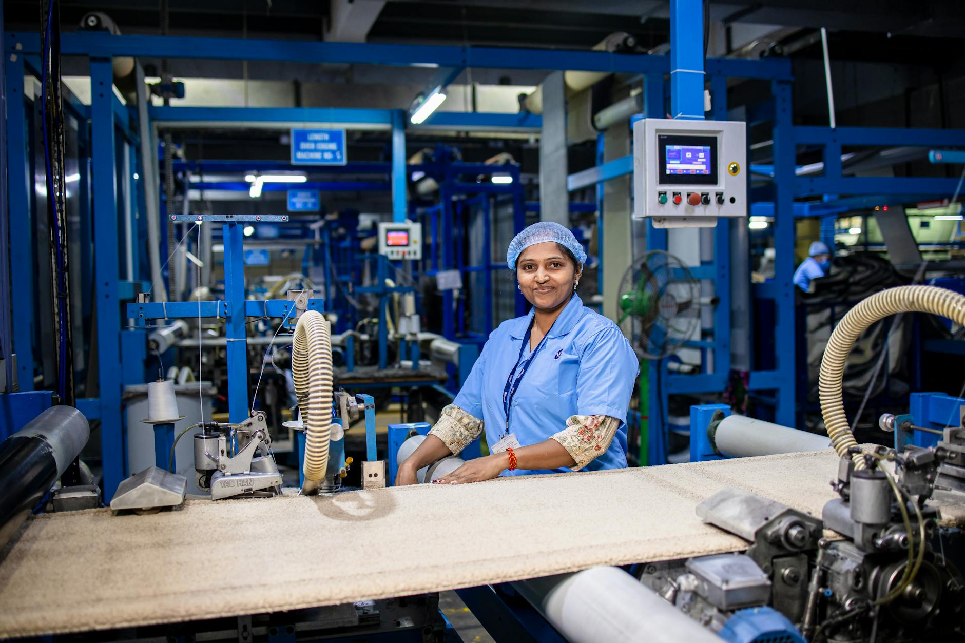 Smiling female worker in a modern textile factory, showcasing the industrial workspace.