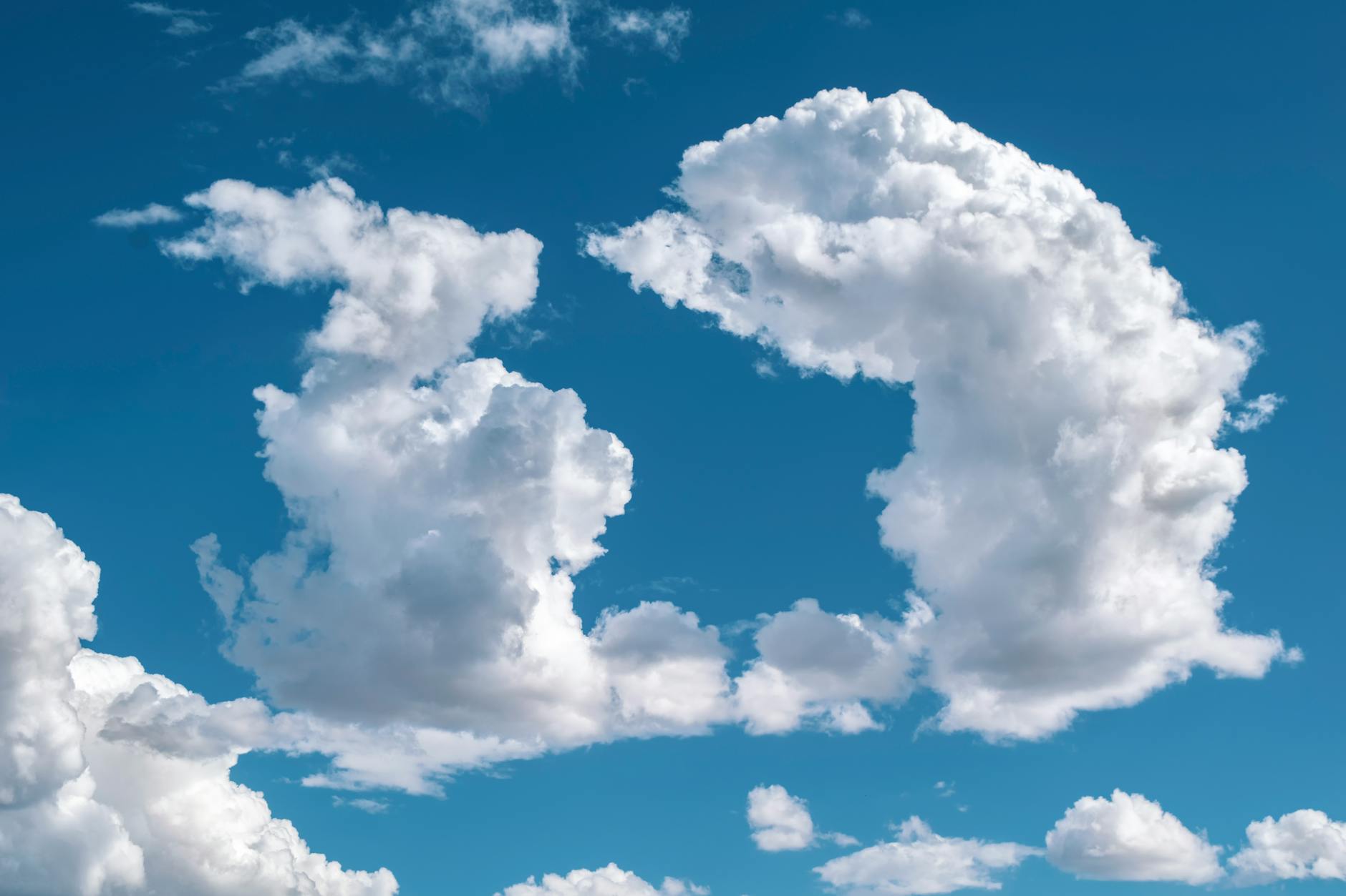 A mesmerizing cloudscape showing fluffy white clouds against a bright blue sky.