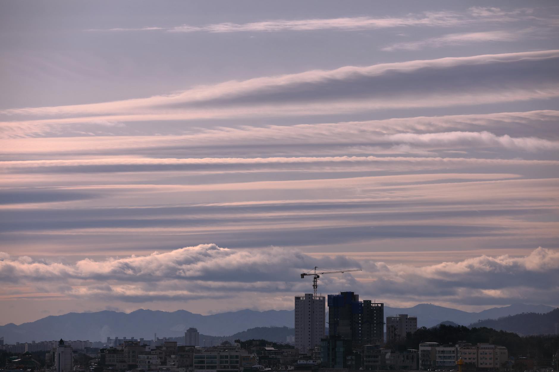 A stunning view of dramatic clouds at dusk over the Goseong-gun skyline, capturing urban development and nature.