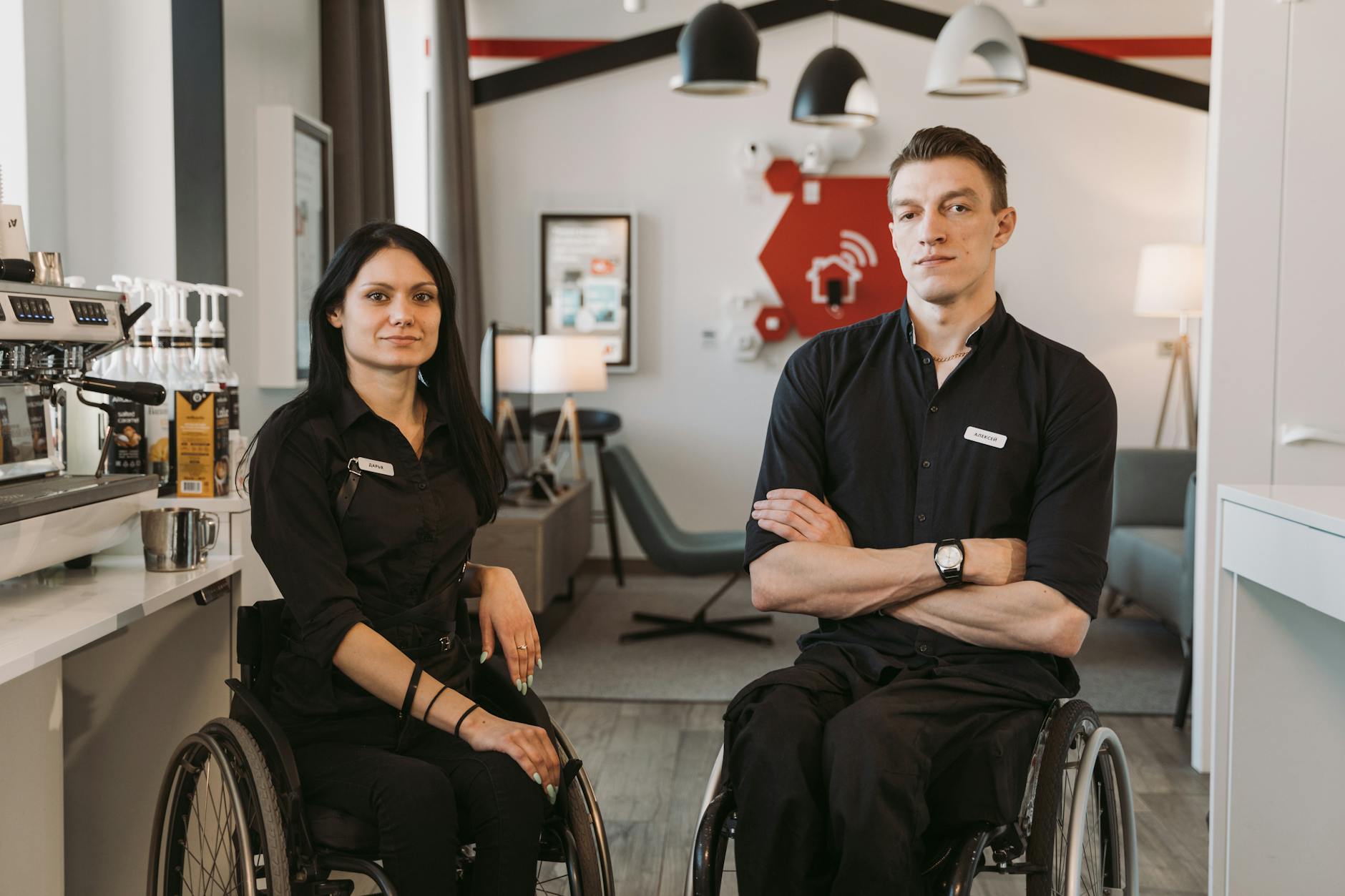 Confident baristas in wheelchairs showcasing diversity in a modern café setting.